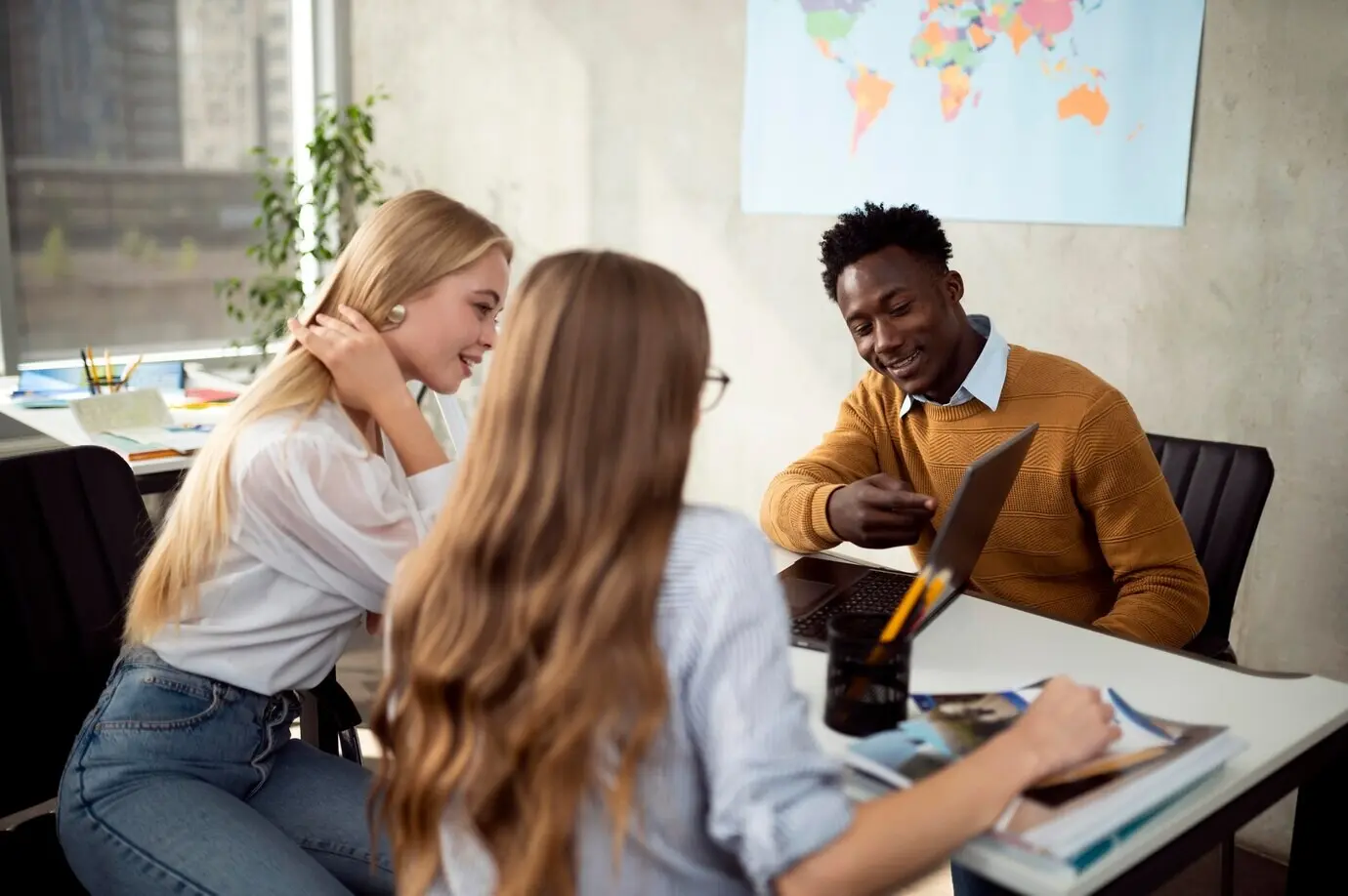 Halbnahe Einstellung von Personen, die auf einen Laptop blicken.