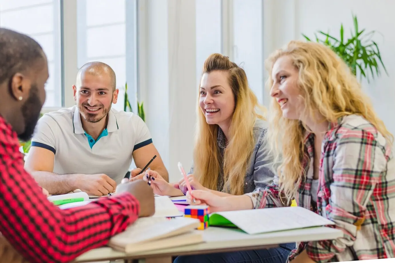 Lachende Menschen an einem Schreibtisch.