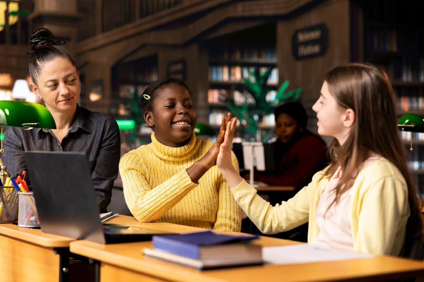 Fröhliche, vielfältige Klassenkameraden geben sich während des Privatunterrichts mit einem Tutor ein High Five.